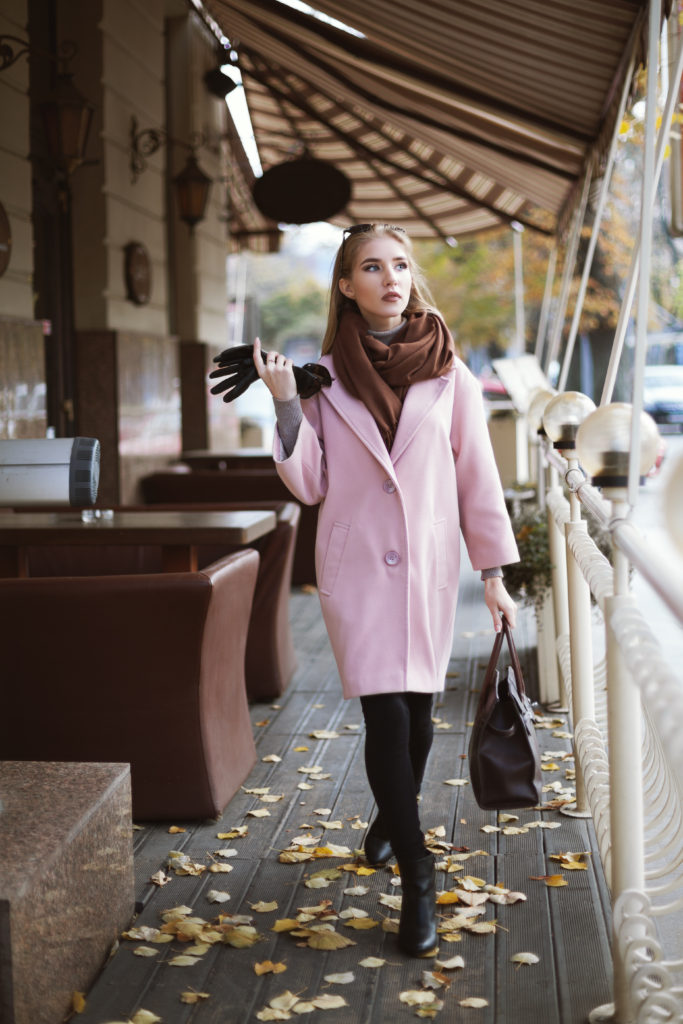 Well dressed woman in a pink coat and black stockings