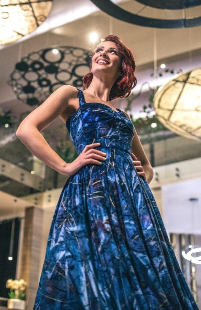 Redhead woman in a blue dress.